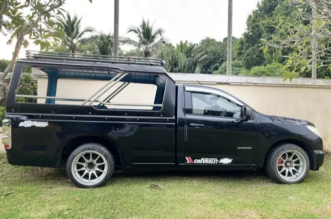 A black pickup taxi with a covered passenger area