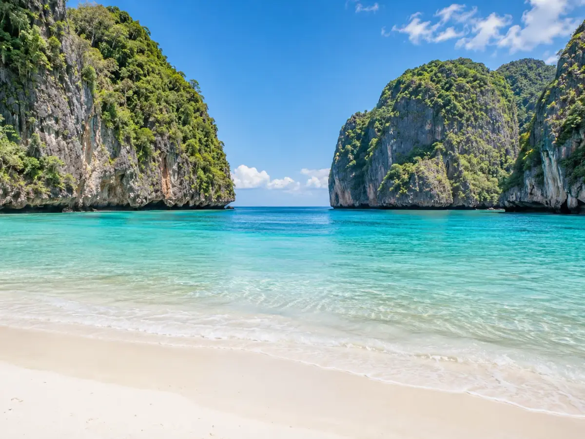 Maya Bay’s white sand beach surrounded by tall limestone cliffs in the Phi Phi Islands